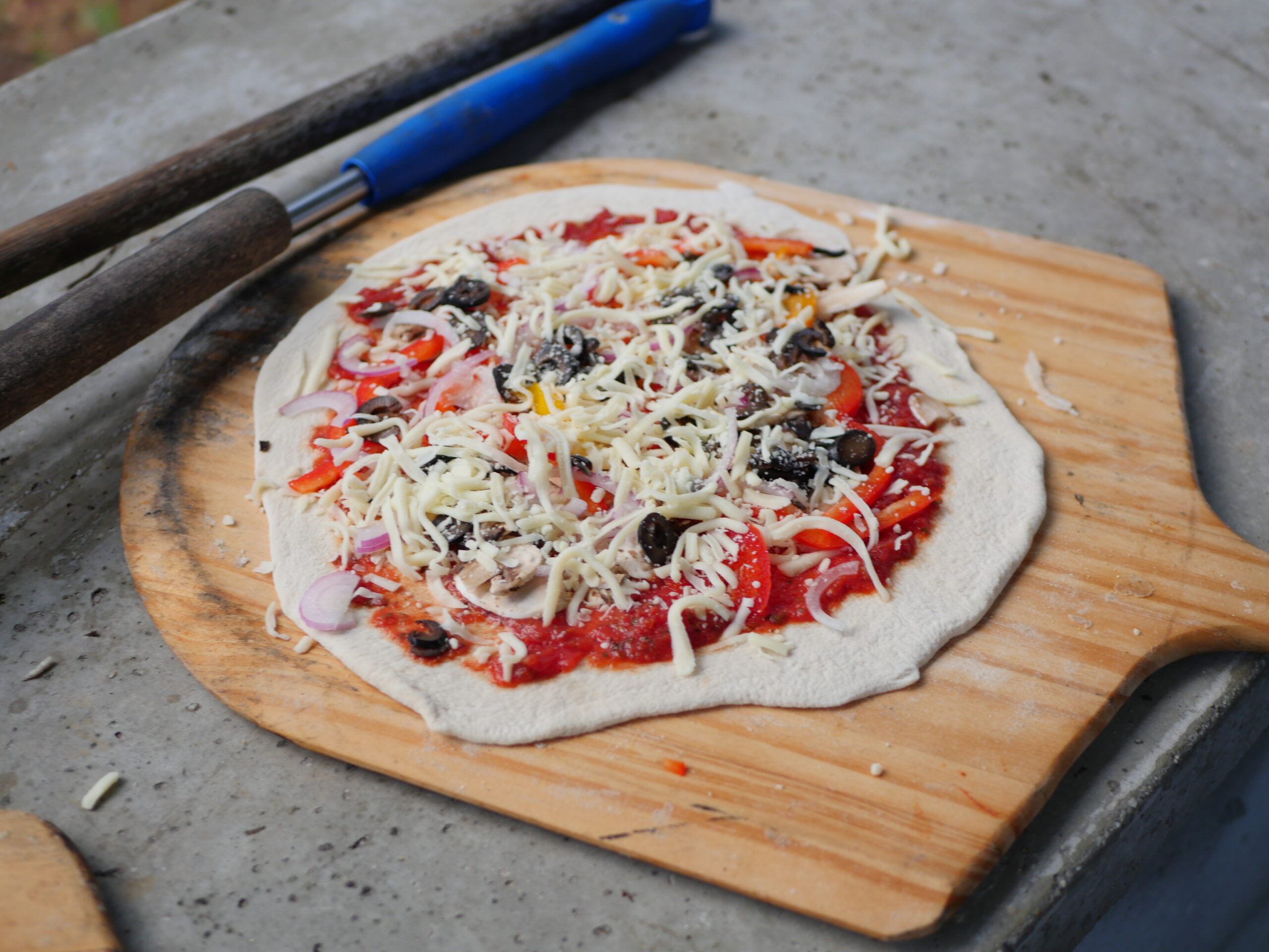 uncooked pizza. fresh handmade dough with house made sauce and fresh toppings.