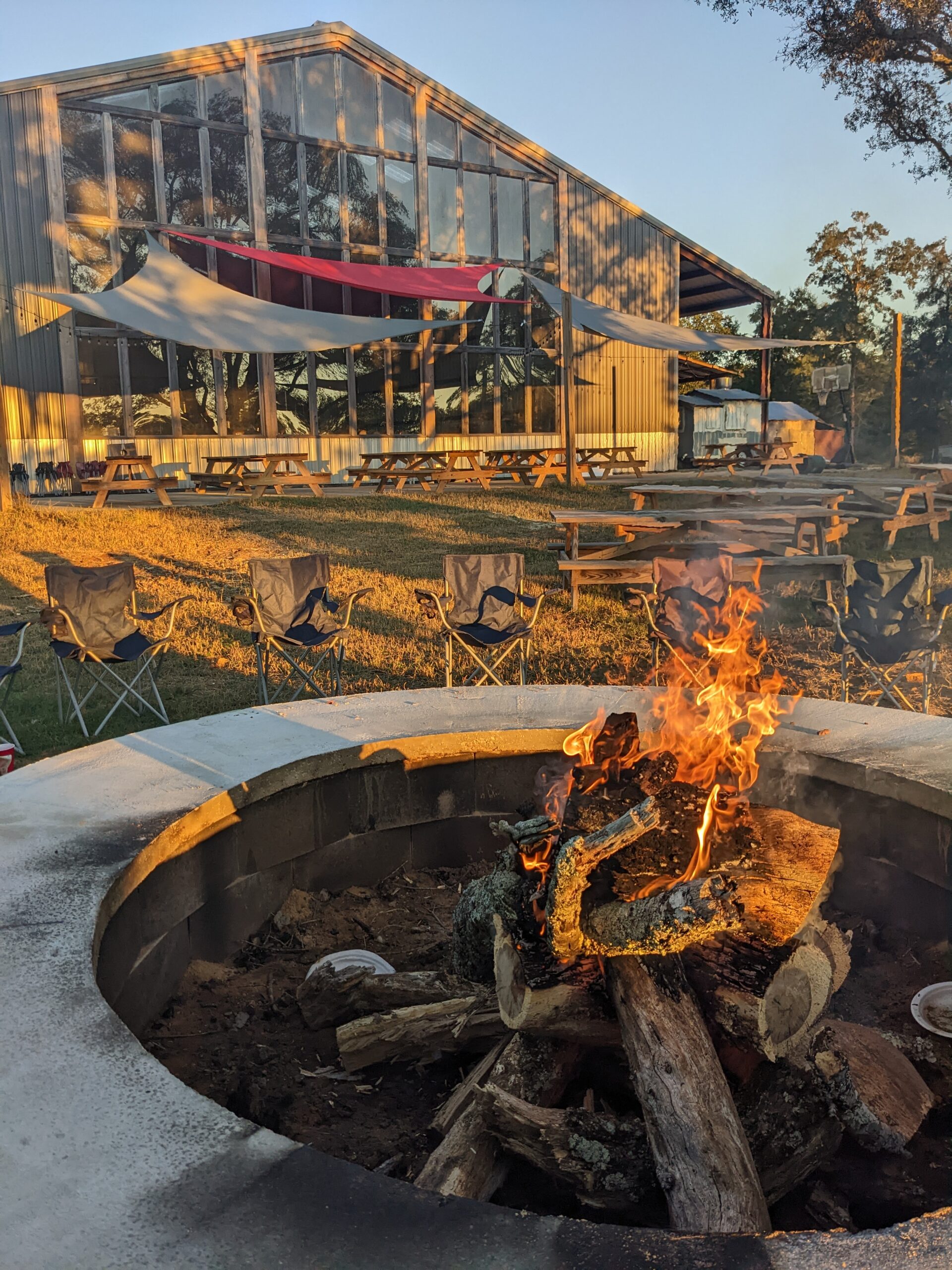 a blazing fire looking back at the window wall and patio behind the distillery