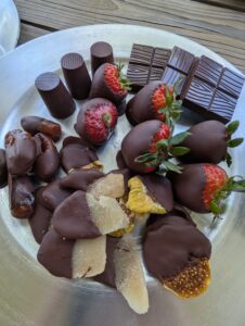 Handmade chocolate covered strawberries, figs, ginger, cherries. with a couple bars of chocolate on the side.